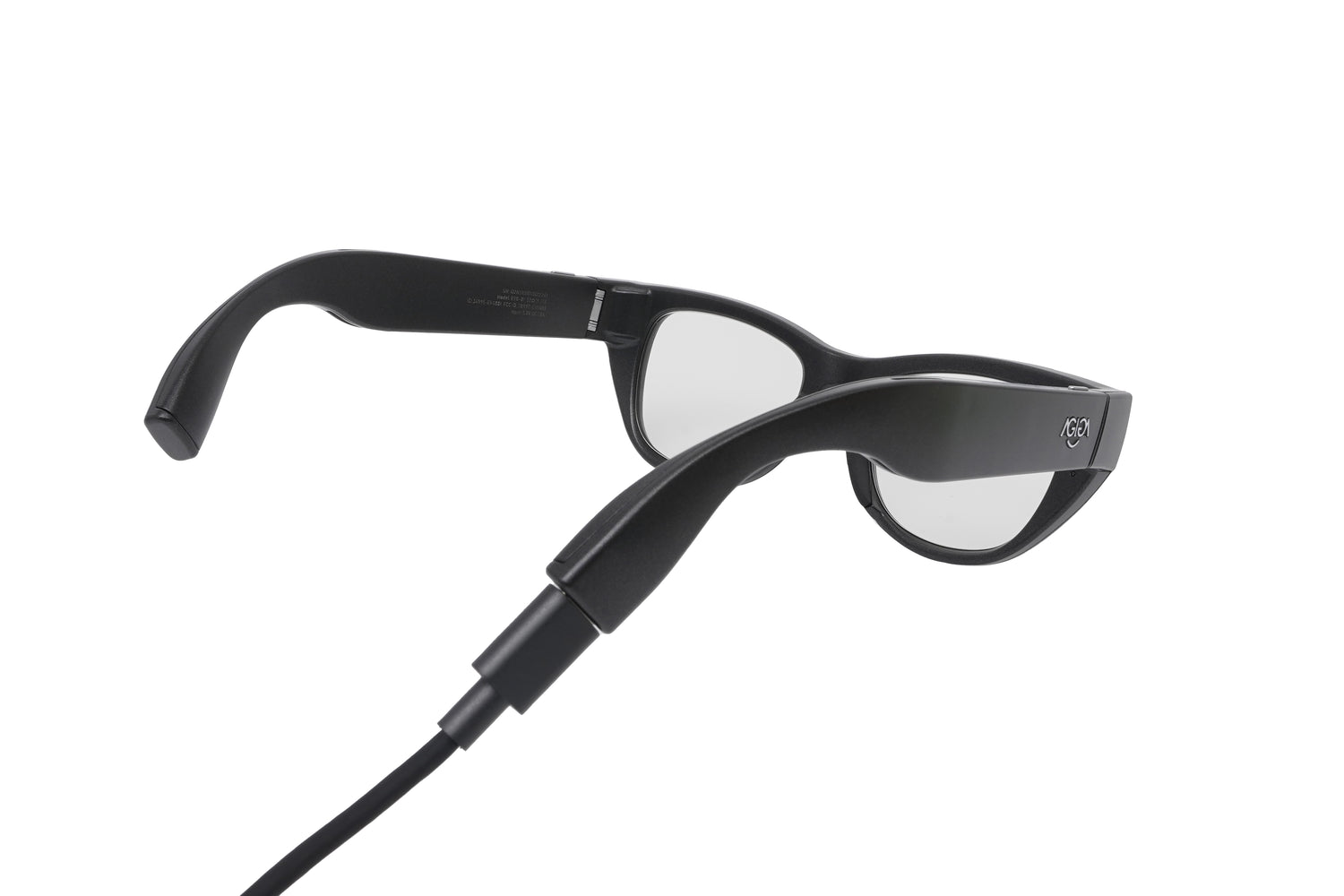 A close-up of the rear of the EchoVision glasses, showing a black USB-C charging cable plugged into the port located at the very tip of the right temple.